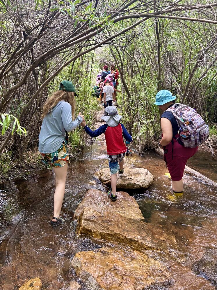 Camp Director Meghan Baker (left) and educator Isabel Rodriguez (Right) help campers cross the Santa Fe River, usually one of the highlights of the week at RDAC.